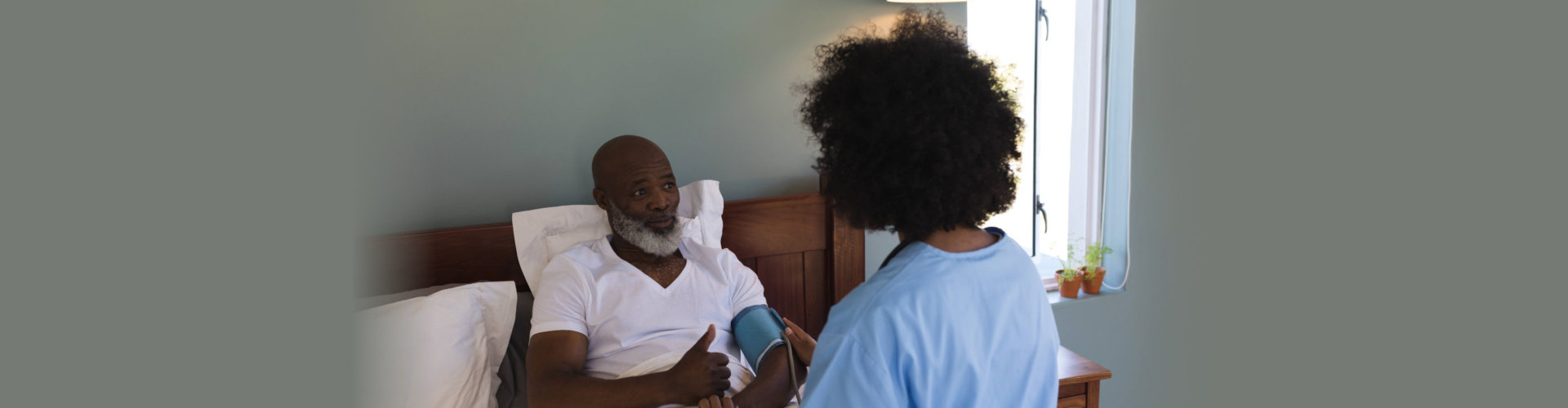 caregiver checking blood pressure of senior man